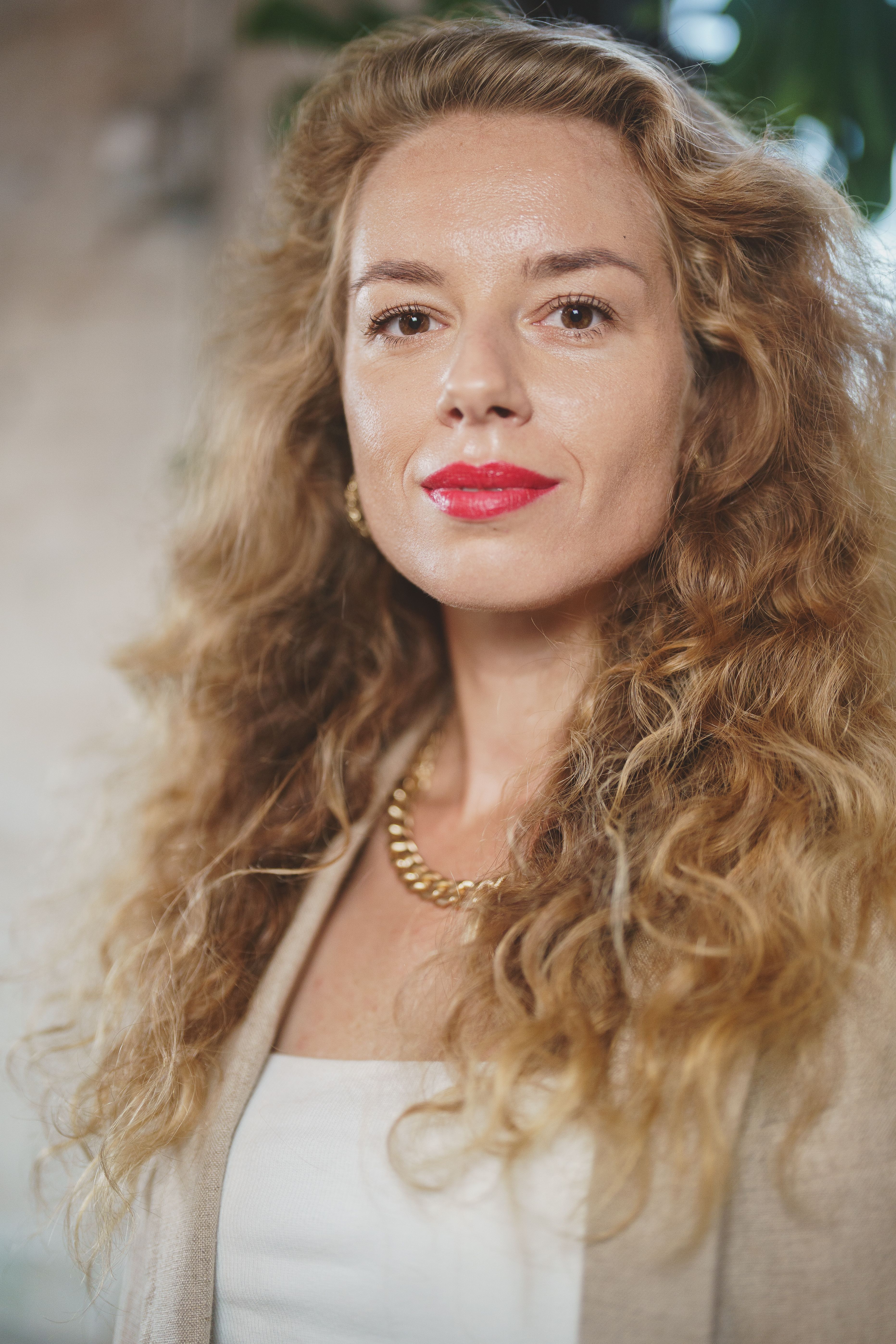 Portrait of a confident woman with curly hair and red lipstick, exuding elegance and strength.