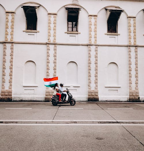 Man and Woman Riding on a Motorbike Holding a Flag of India