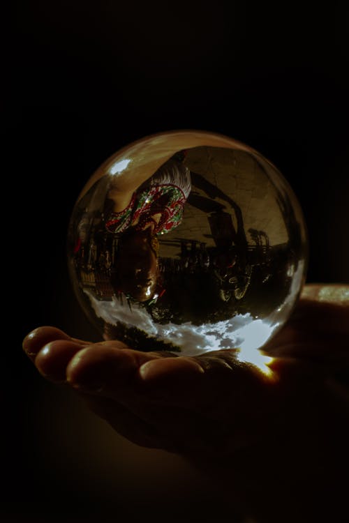 Close-up of a Person Holding a Glass Ball 