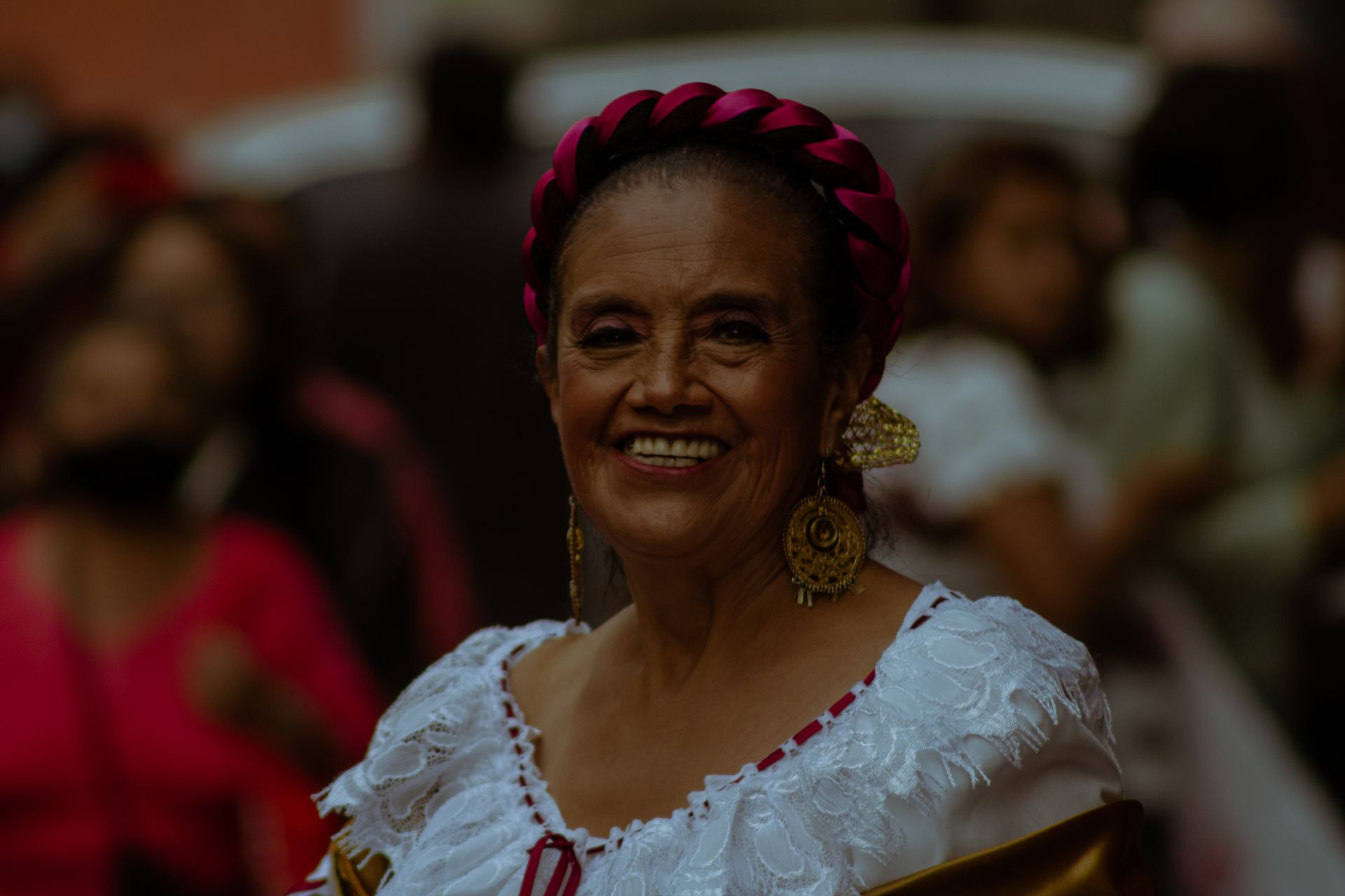 Elderly woman smiling wearing traditional Mexican attire during a celebration in Puebla, Mexico.