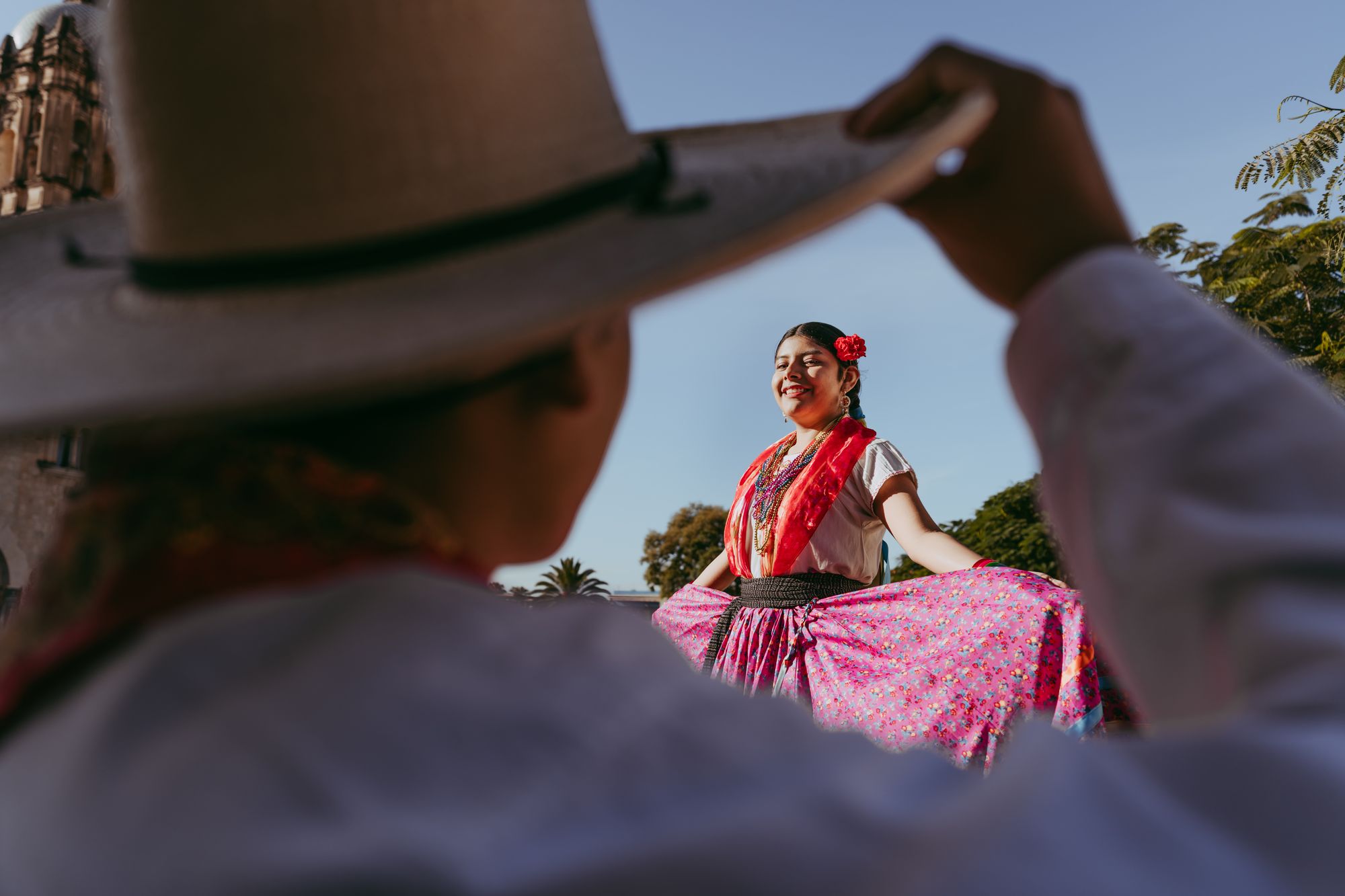 A woman in vibrant traditional dress performing a Mexican folk dance in Oaxaca, Mexico.
