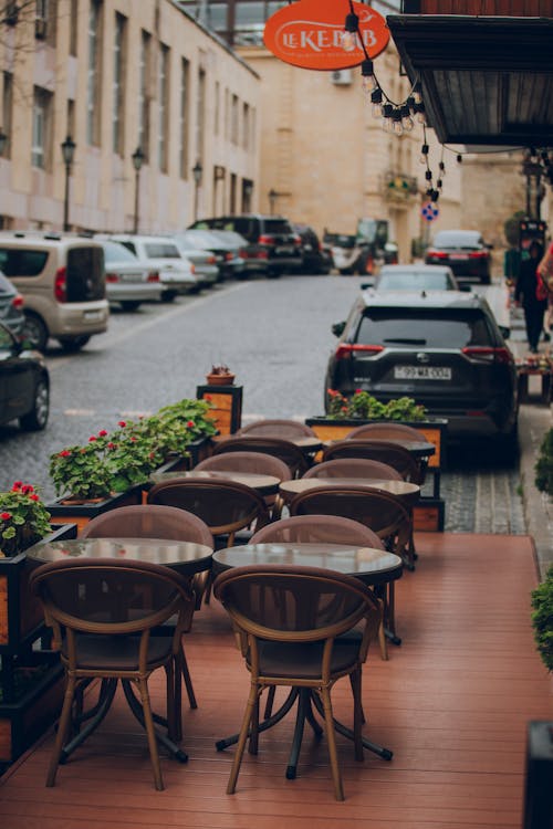 Brown Wooden Chairs and Table on Sidewalk
