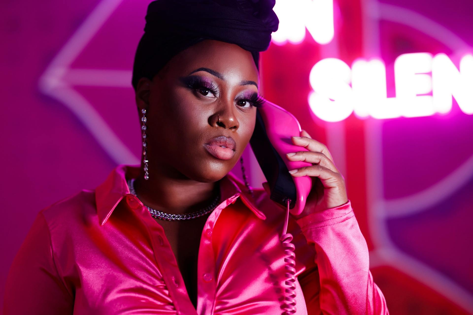 Woman in a Pink Top Using a Telephone