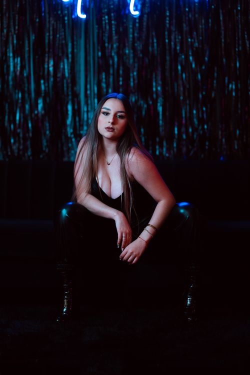 Free Confident woman posing in a nightclub with a dark and stylish atmosphere in Orlando. Stock Photo