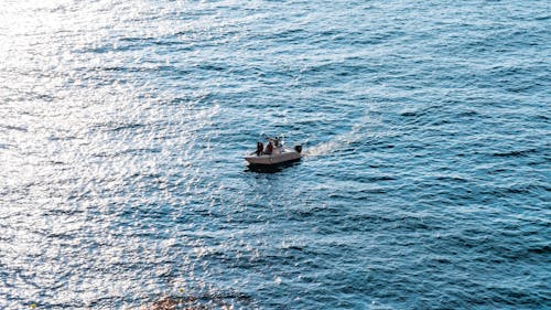 People Riding a Boat on a Body of Water