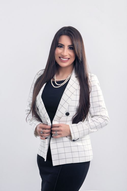 Free Elegant business woman in black dress and white blazer, exuding confidence. Stock Photo