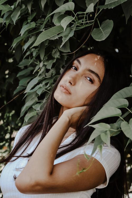 Woman in White Top Standing Beside Green Leaves · Free Stock Photo