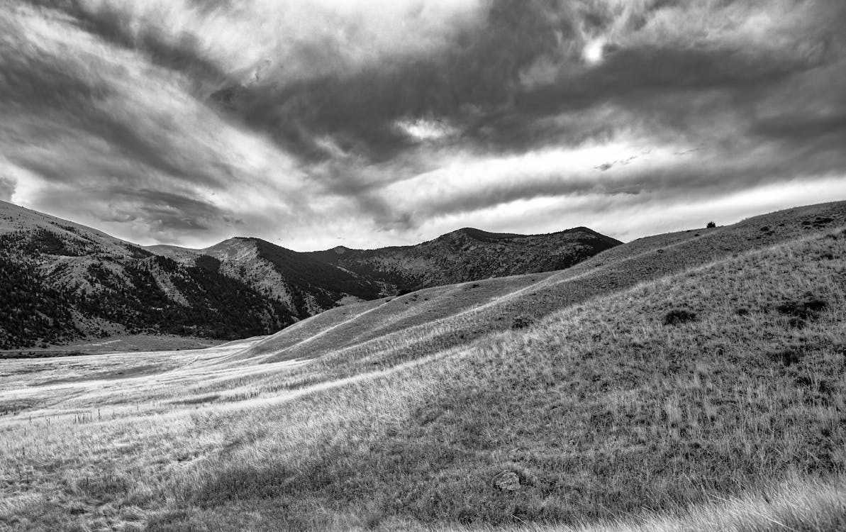 Immagine gratuita di bianco e nero, campo d'erba, catene montuose