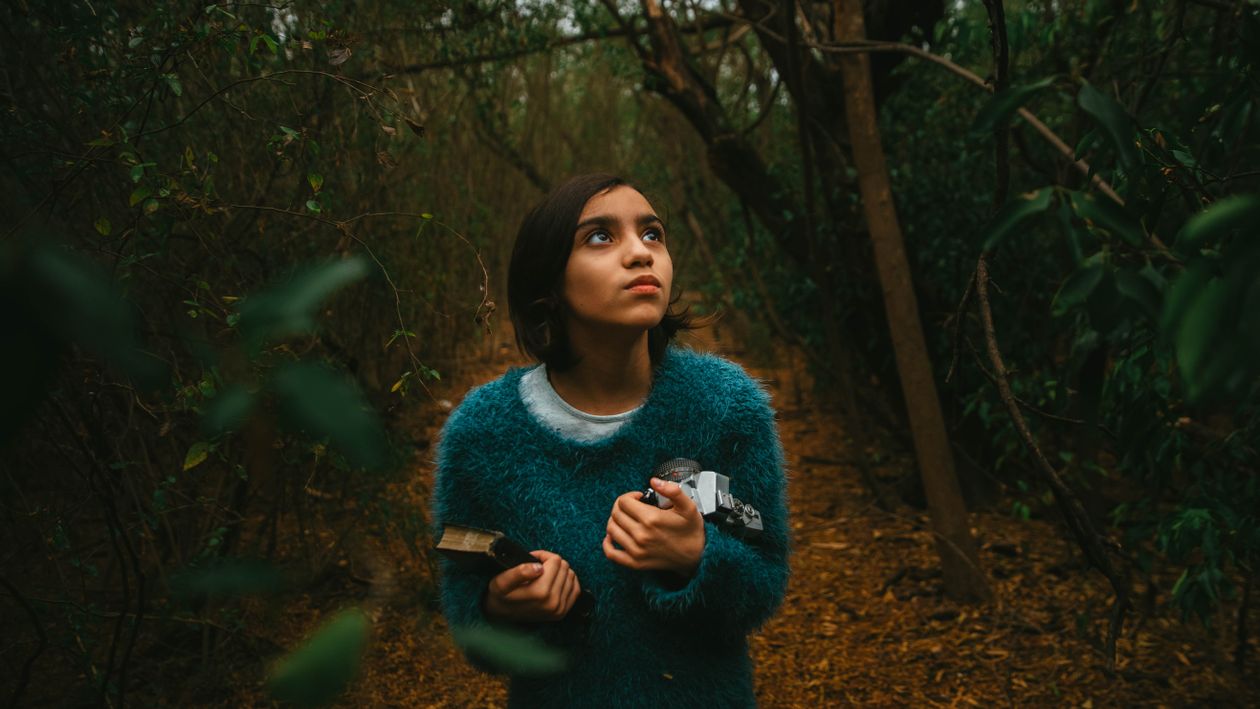 A Woman Standing in the Forest while Looking Around · Free Stock Photo