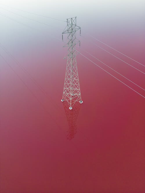 Aerial View of a Utility Pole and Lines on Pink Water 