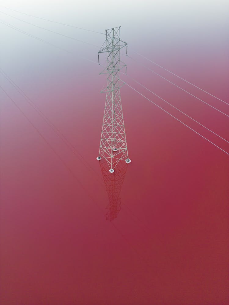 Aerial View Of A Utility Pole And Lines On Pink Water 