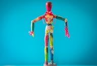 在各种颜色的蓝色背景下，一个充满活力的木制人体模型画脱颖而出