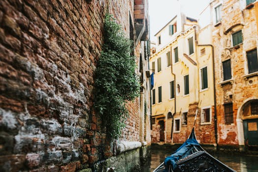 A picturesque view of a gondola navigating through a Venetian canal surrounded by historic brick buildings.