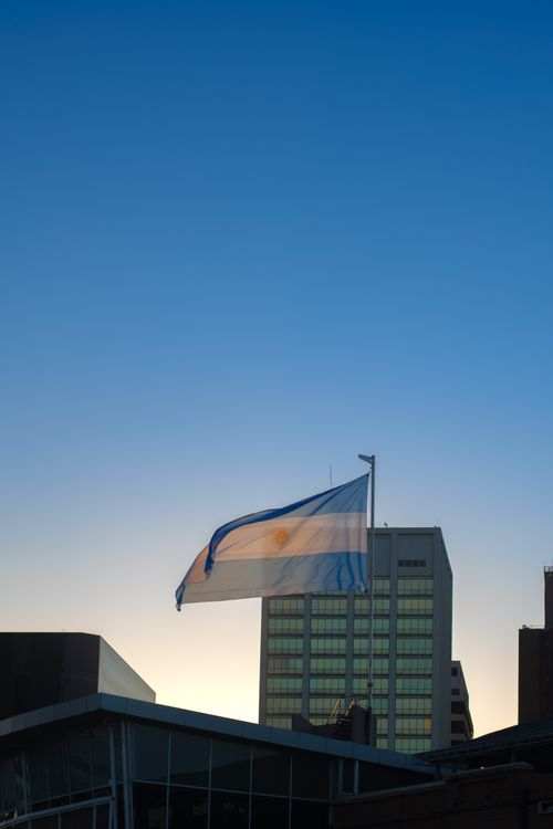 Free Historic Buenos Aires skyline with the Argentinian flag waving against a clear blue sky. Stock Photo