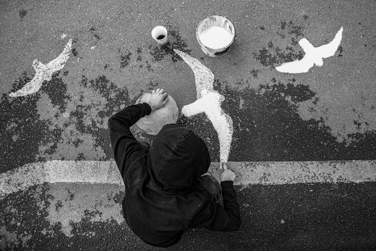 Boy Painting Birds On Asphalt