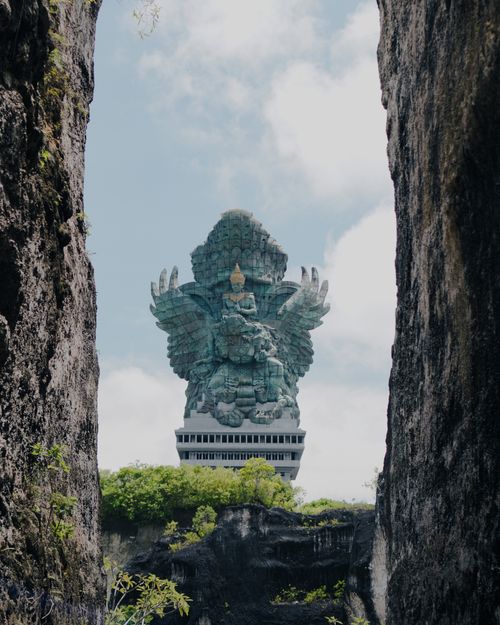 Free Garuda Wisnu Kencana statue framed by cliffs, highlighting Bali's cultural and religious heritage. Stock Photo
