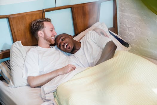 Joyful moments shared between a loving gay couple relaxing in bed, capturing warmth and togetherness.