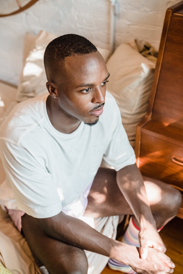 Man Sitting On The Bed In The Morning 