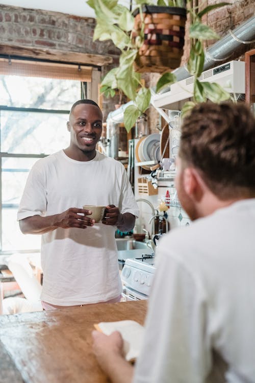 Smiling Man Looking at Boyfriend in a Kitchen 