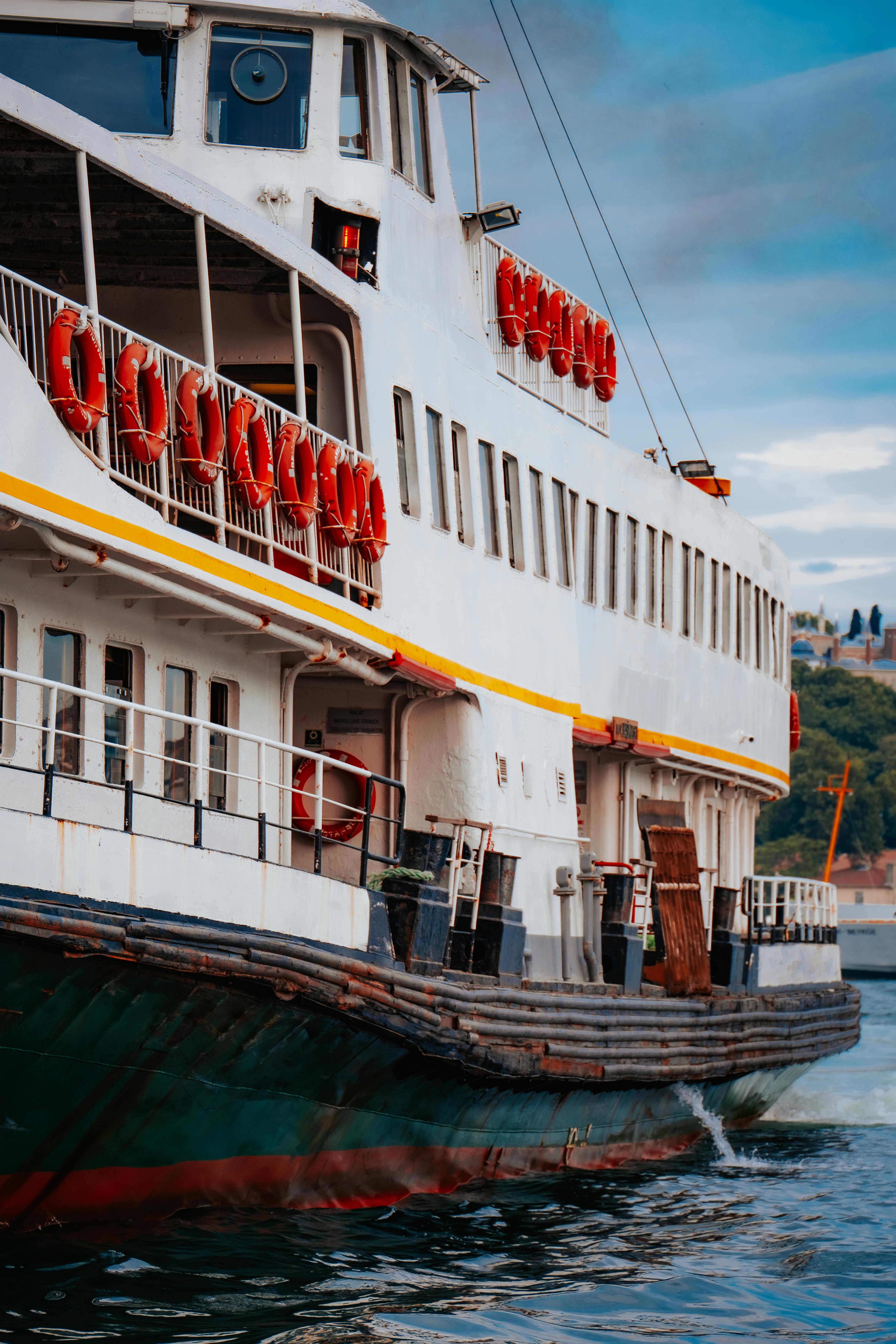 A colorful ferry boat navigates calm waters under a bright blue sky, offering a serene travel experience.