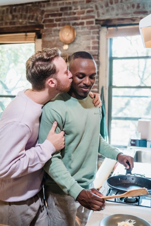 Free A loving couple cooking together and sharing a tender moment in their kitchen, highlighting lifestyle and affection. Stock Photo