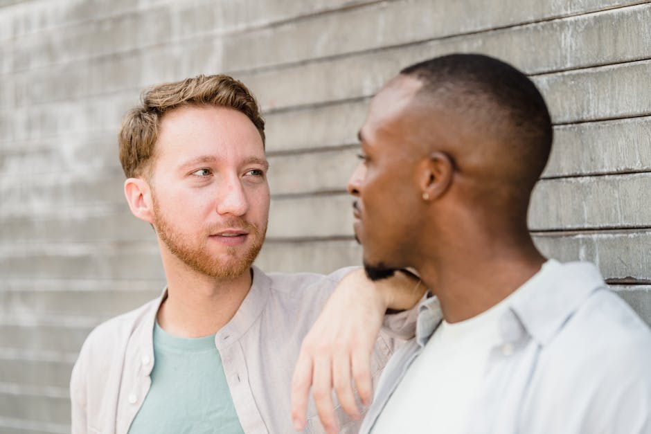 A close-up portrait of two men sharing a moment outdoors, depicting friendship and connection.