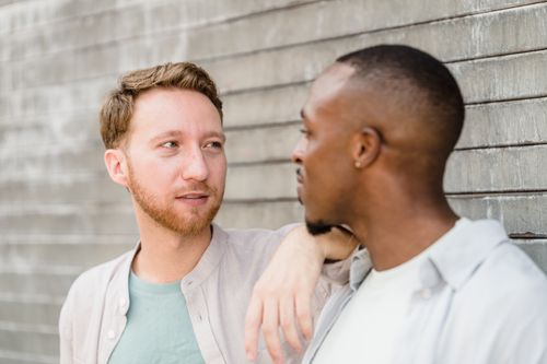 Free A close-up portrait of two men sharing a moment outdoors, depicting friendship and connection. Stock Photo