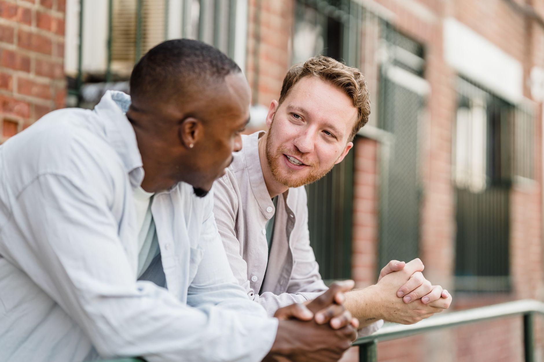 Two young men engaged in a lively conversation outdoors