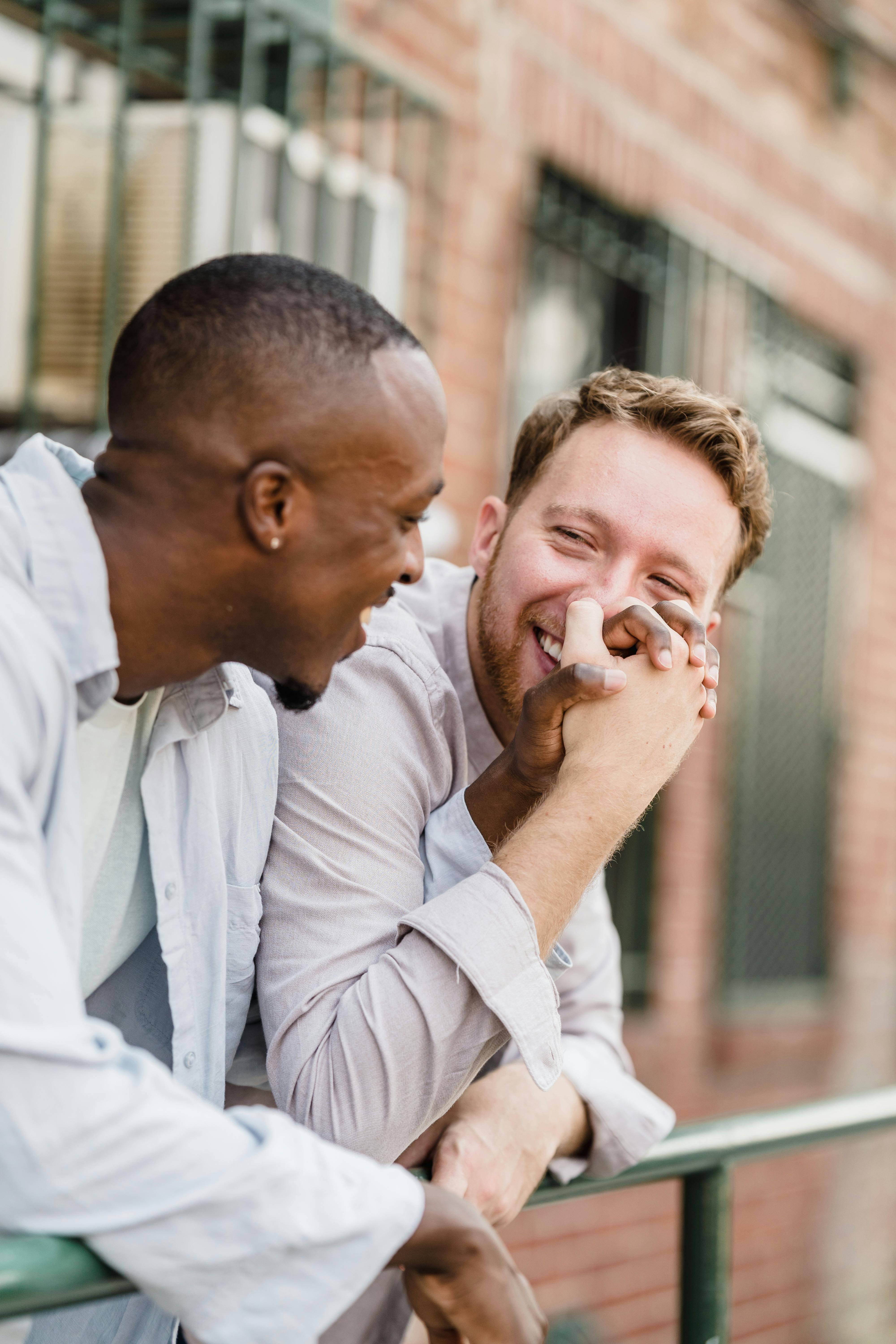 Two Men Holding Hands And Smiling At Each Other · Free Stock Photo