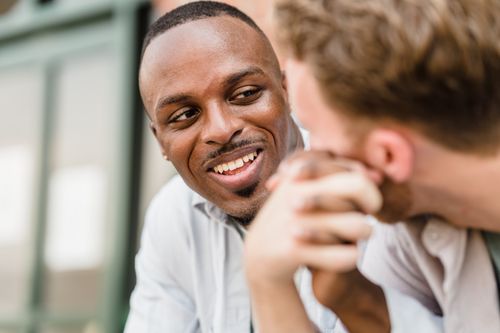 Free Close-up of a smiling couple sharing a tender moment while holding hands outdoors. Stock Photo