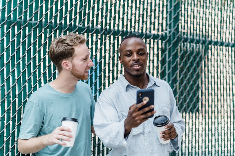 Couple With Coffee Cups Using Smart Phone