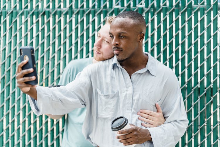 Couple With Coffee Cups Using Smart Phone