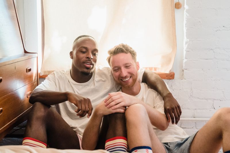 Affectionate couple enjoying a cozy moment at home, sitting comfortably and smiling.