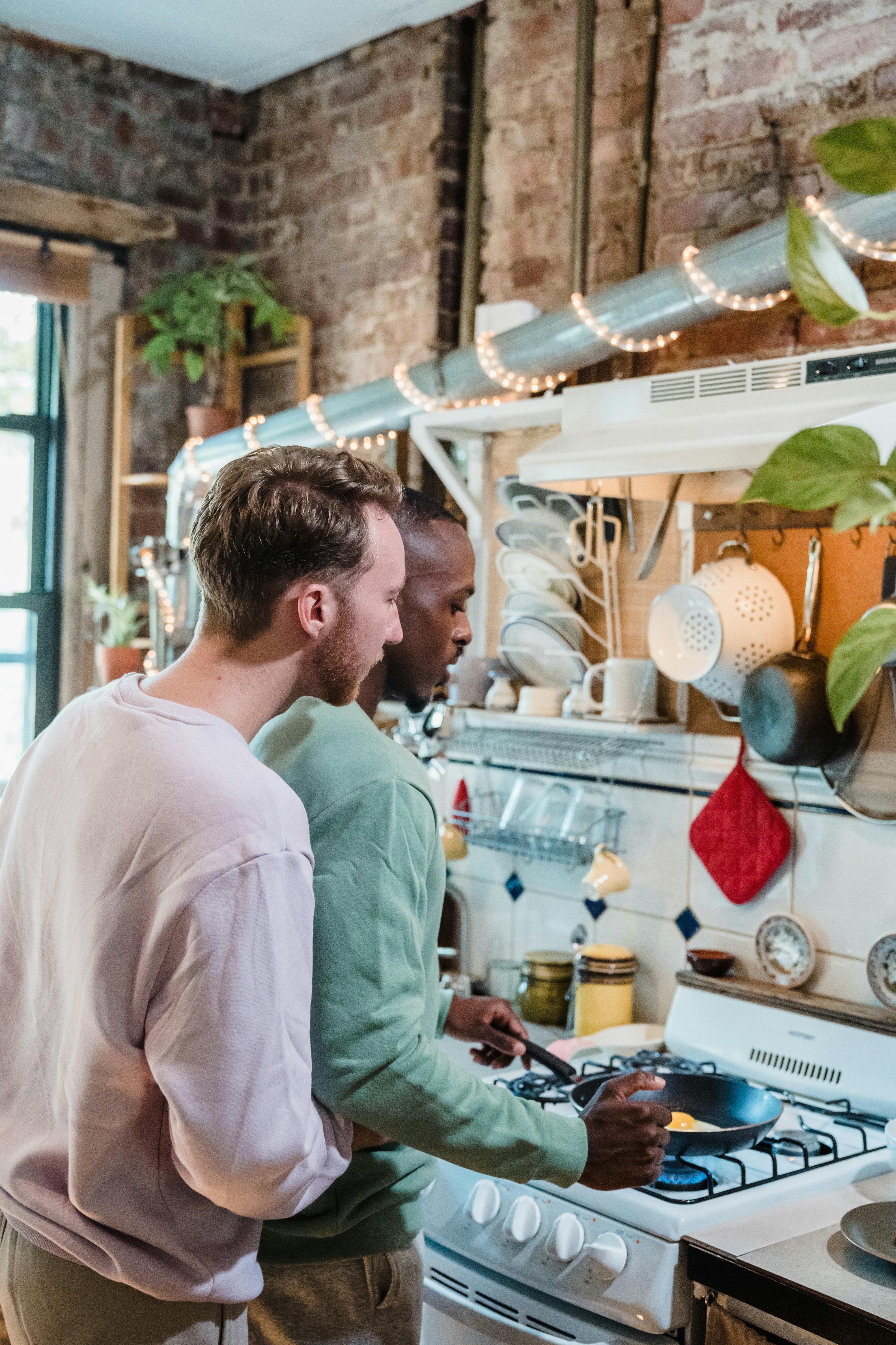 A loving couple enjoys cooking in a rustic kitchen, creating a warm, homey atmosphere.