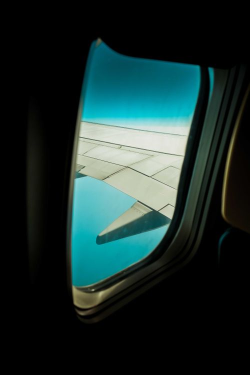 Free A clear view of an airplane wing and sky, seen through a plane window, evokes travel inspiration. Stock Photo