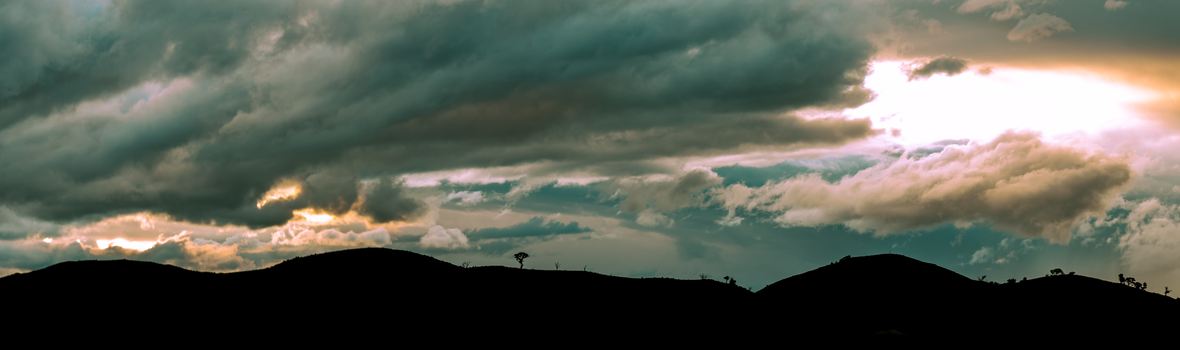 Silhouetted hills under a dramatic cloudy sky at twilight in Canberra, Australia.