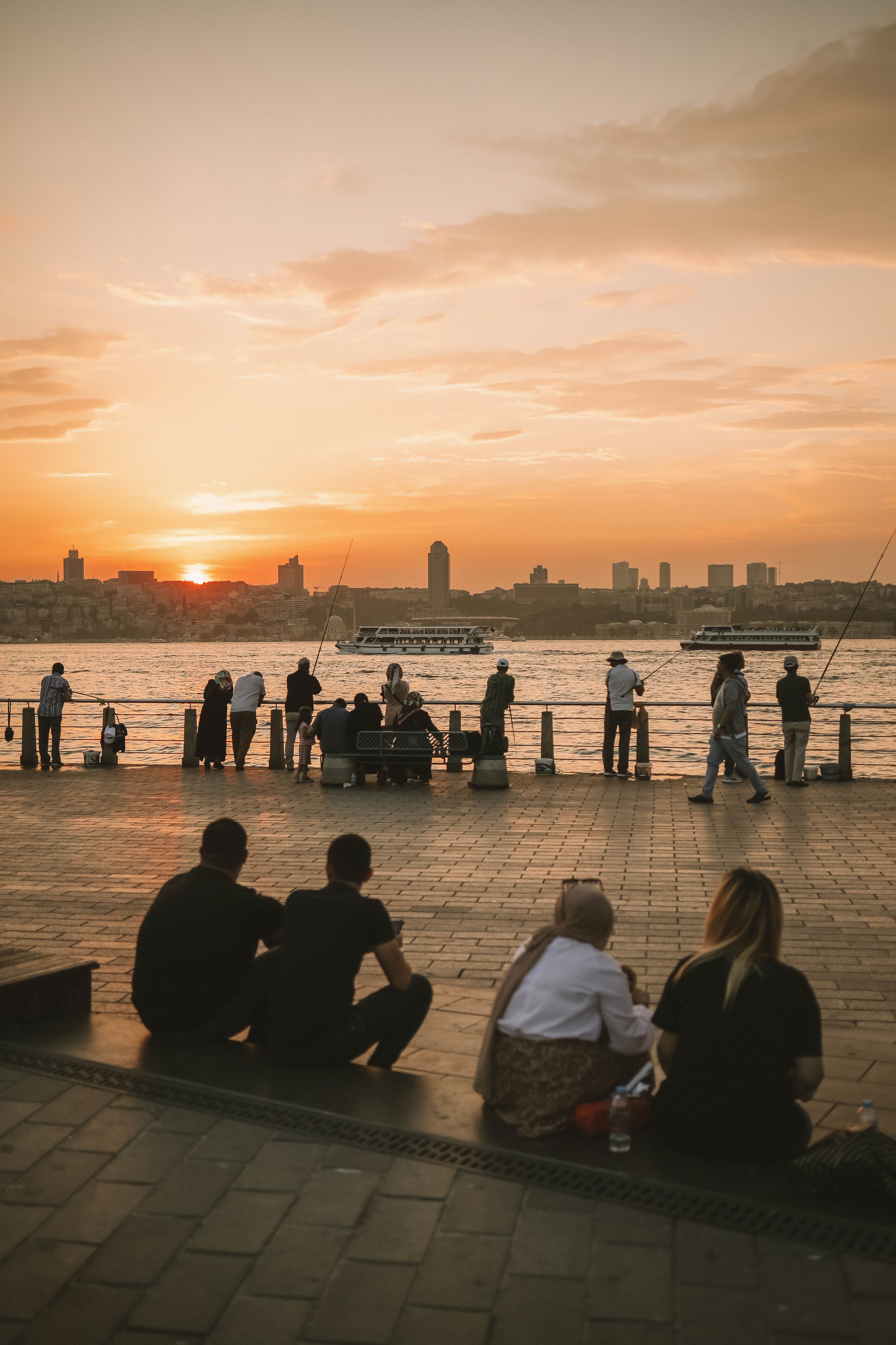 People enjoying the sunset by the waterfront in Istanbul, Turkey, capturing a vibrant city scene.