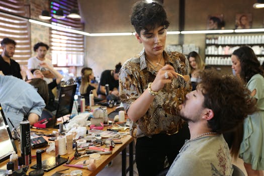 A team of makeup artists working on models in a bustling studio environment.