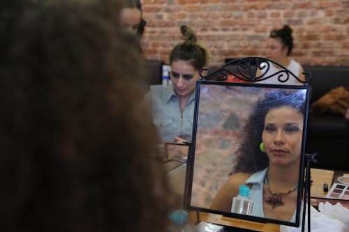 A Woman's Face Reflection over a Mirror