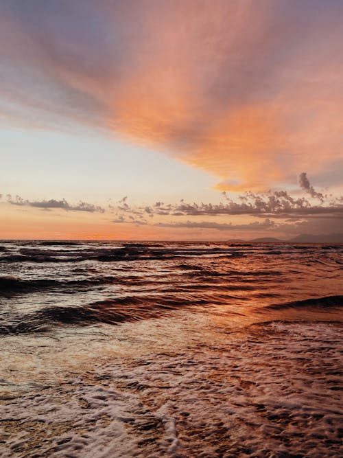 Ocean Waves Under Cloudy Sky during Sunset