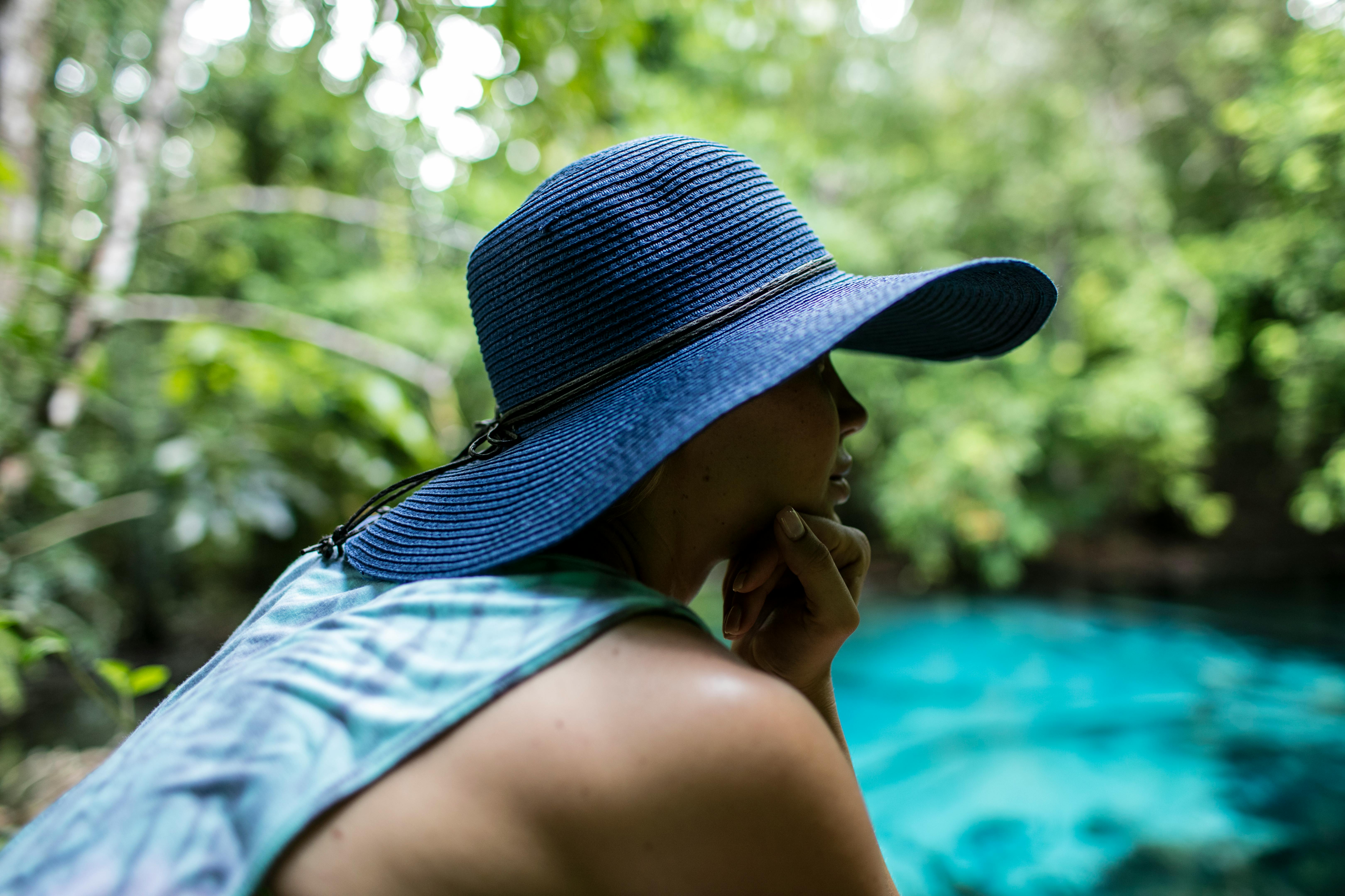 woman wearing blue tank top and blue sunhat