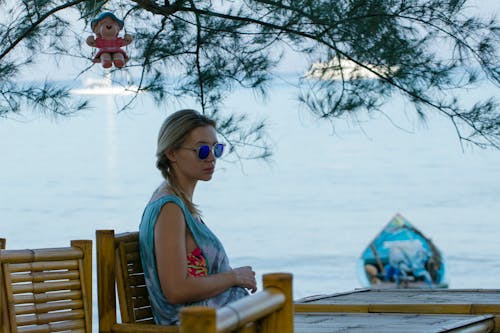 Pregnant Woman Sitting at a Bamboo Table by the Sea