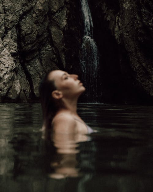 Woman on a Lake near a Waterfall