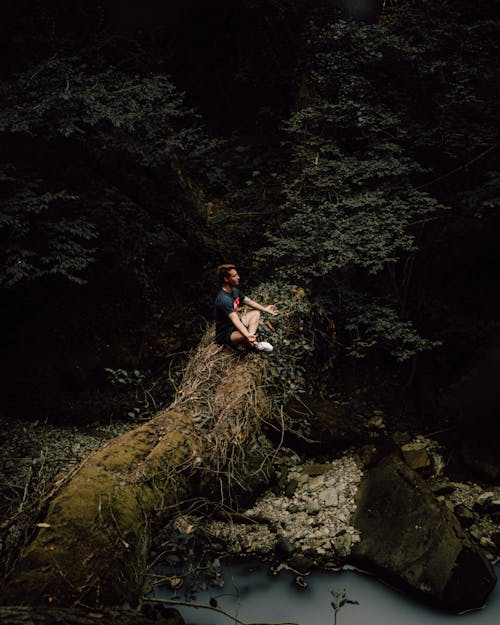 Man Sitting Cross-Legged and Meditating by a River