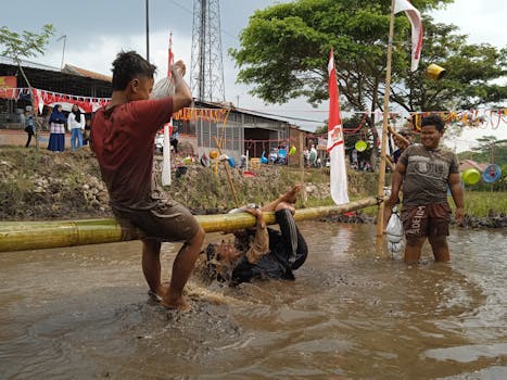 Joyful boys playing on a bamboo pole at a village festival in Garut, Indonesia.