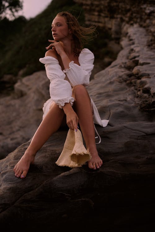Woman in a Dress Sitting on a Beach