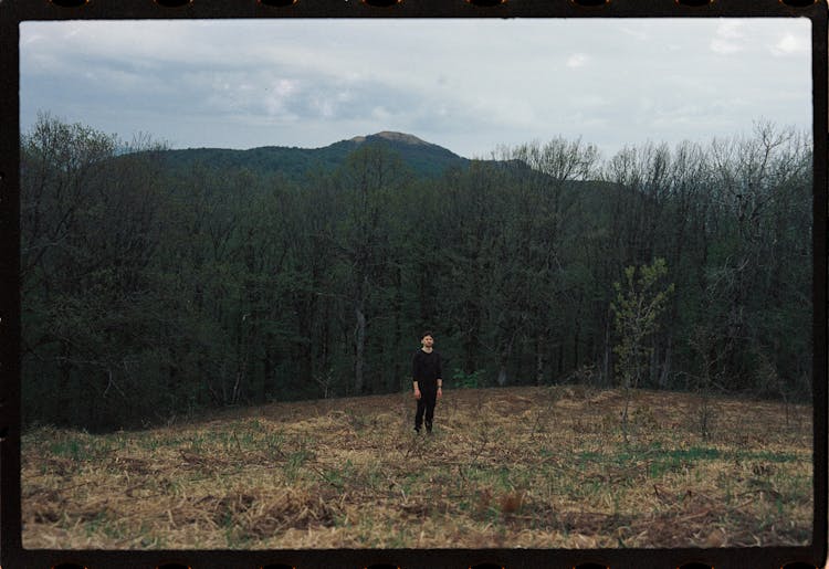 Man Standing On Forest Edge