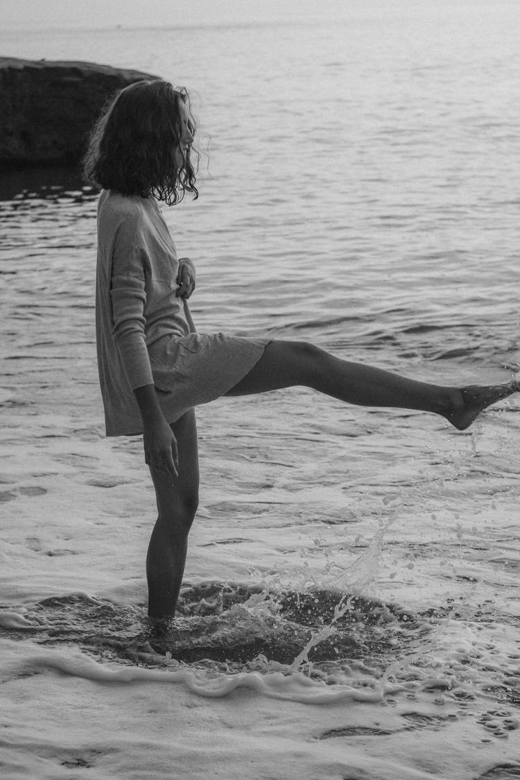 Black And White Photo Of Woman Kicking Sea Water