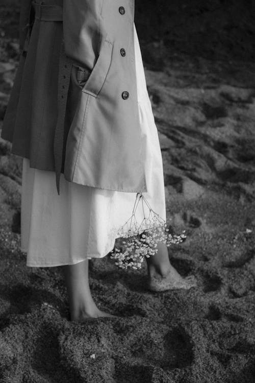 Black and White Photo of Barefoot Woman Walking on Sand