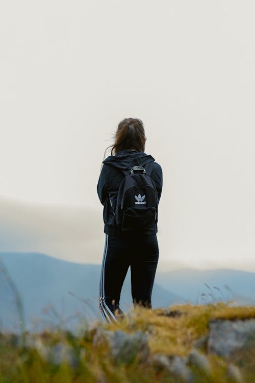 Woman Wearing a Backpack Looking Out onto the Mountains